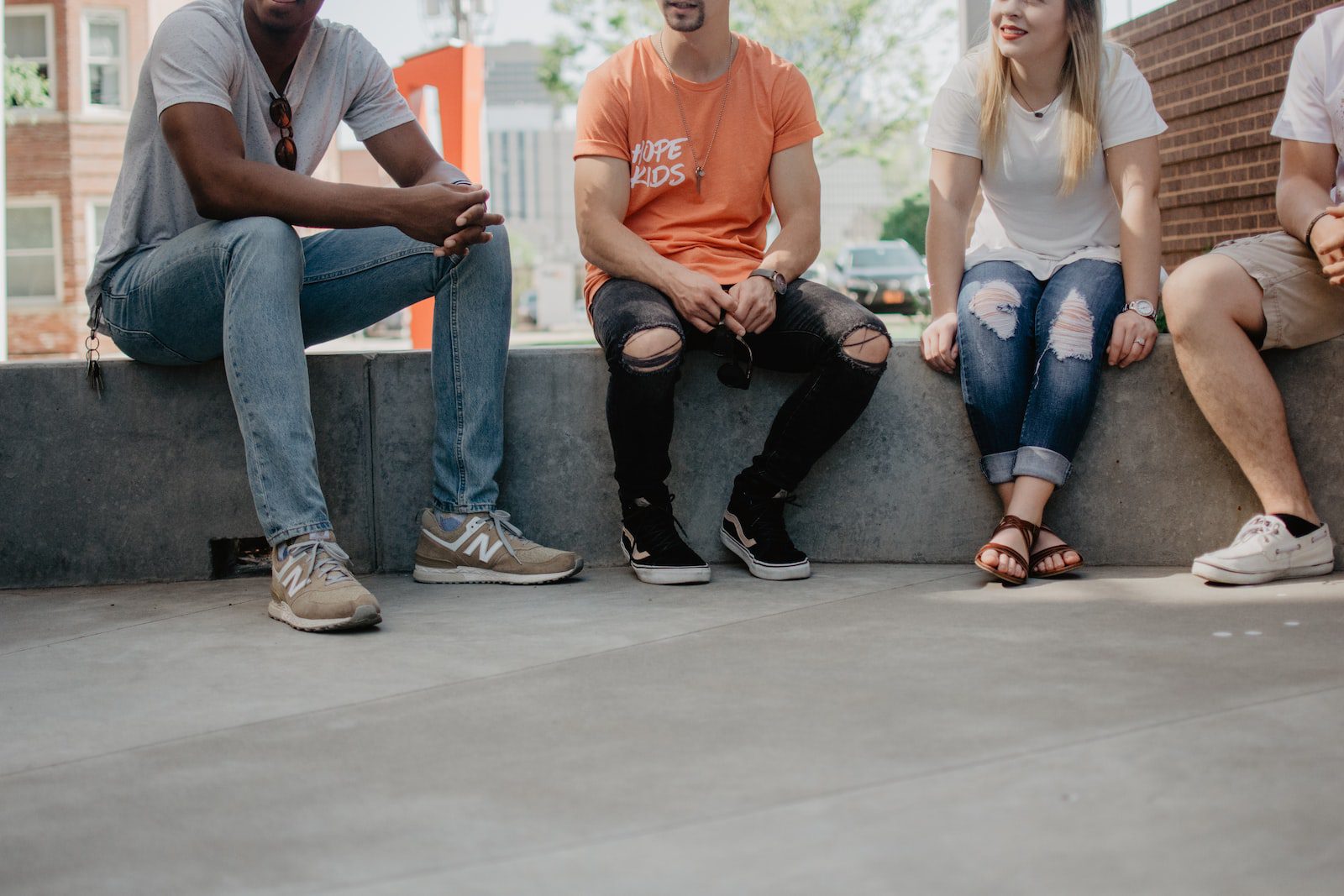 four persons sitting on concrete bench